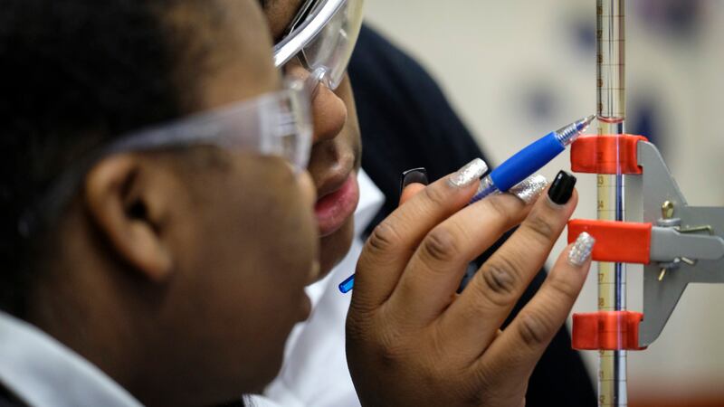 Two students wearing safety glasses take measurements for a science experiment at Providence Cristo Rey High School, a private, Roman Catholic high school in Indianapolis, Indiana.