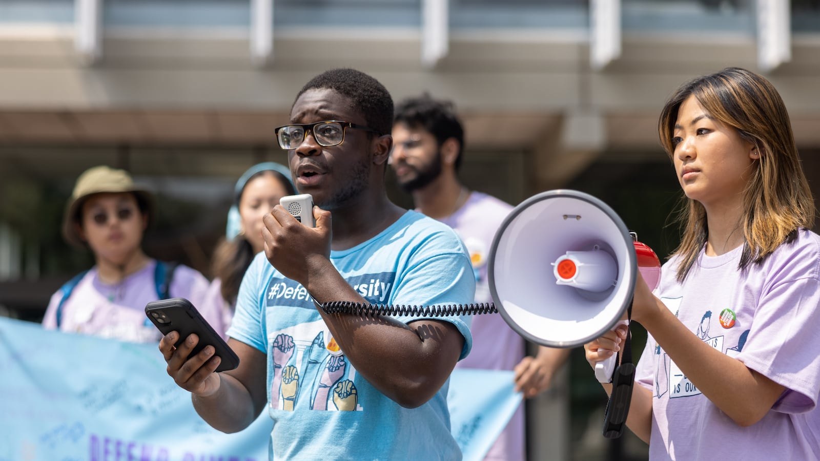 A person speaks into a megaphone at Harvard University’s Science Center Plaza during a rally.
