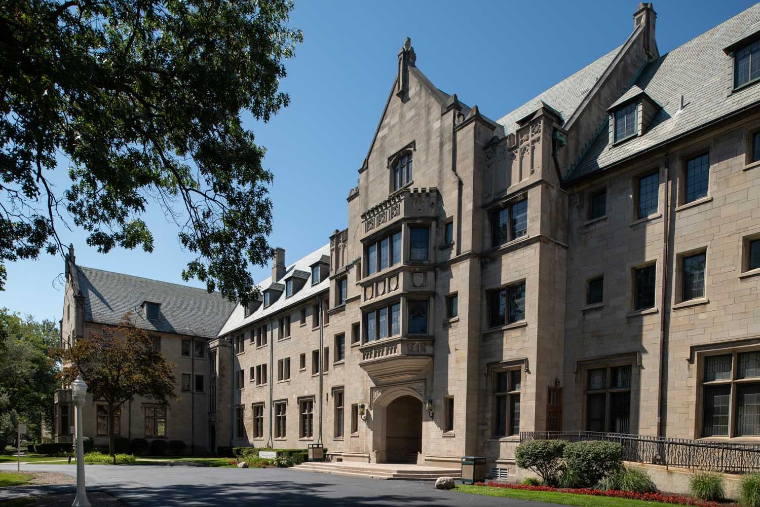 A photograph of a large stone school building on a sunny day.