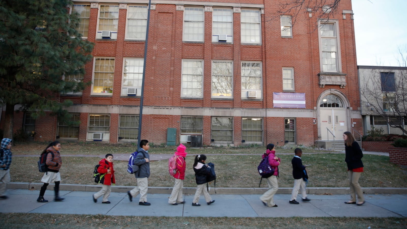 Students at University Prep, a DPS charter school, walk in front of the building with their teacher. (Photo by Marc Piscotty/For Chalkbeat)