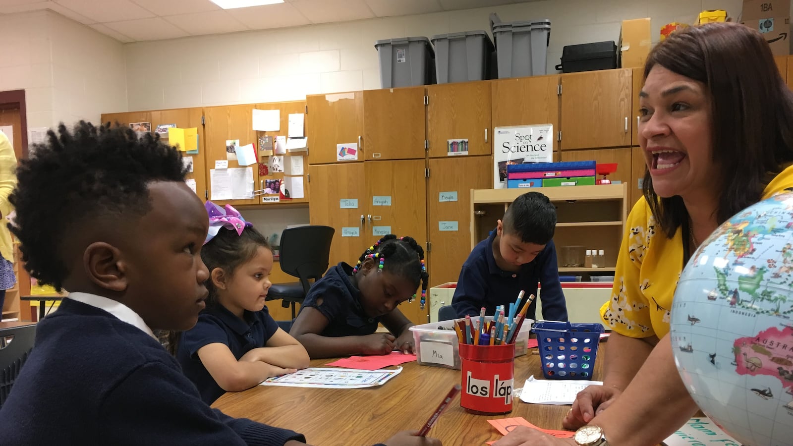 Pre-K teacher Maria Rodriguez sounds out words in Spanish to help 5-year-old Joshua Robinson with a writing exercise. Global Preparatory Academy in Indianapolis has a new bilingual prekindergarten classroom.