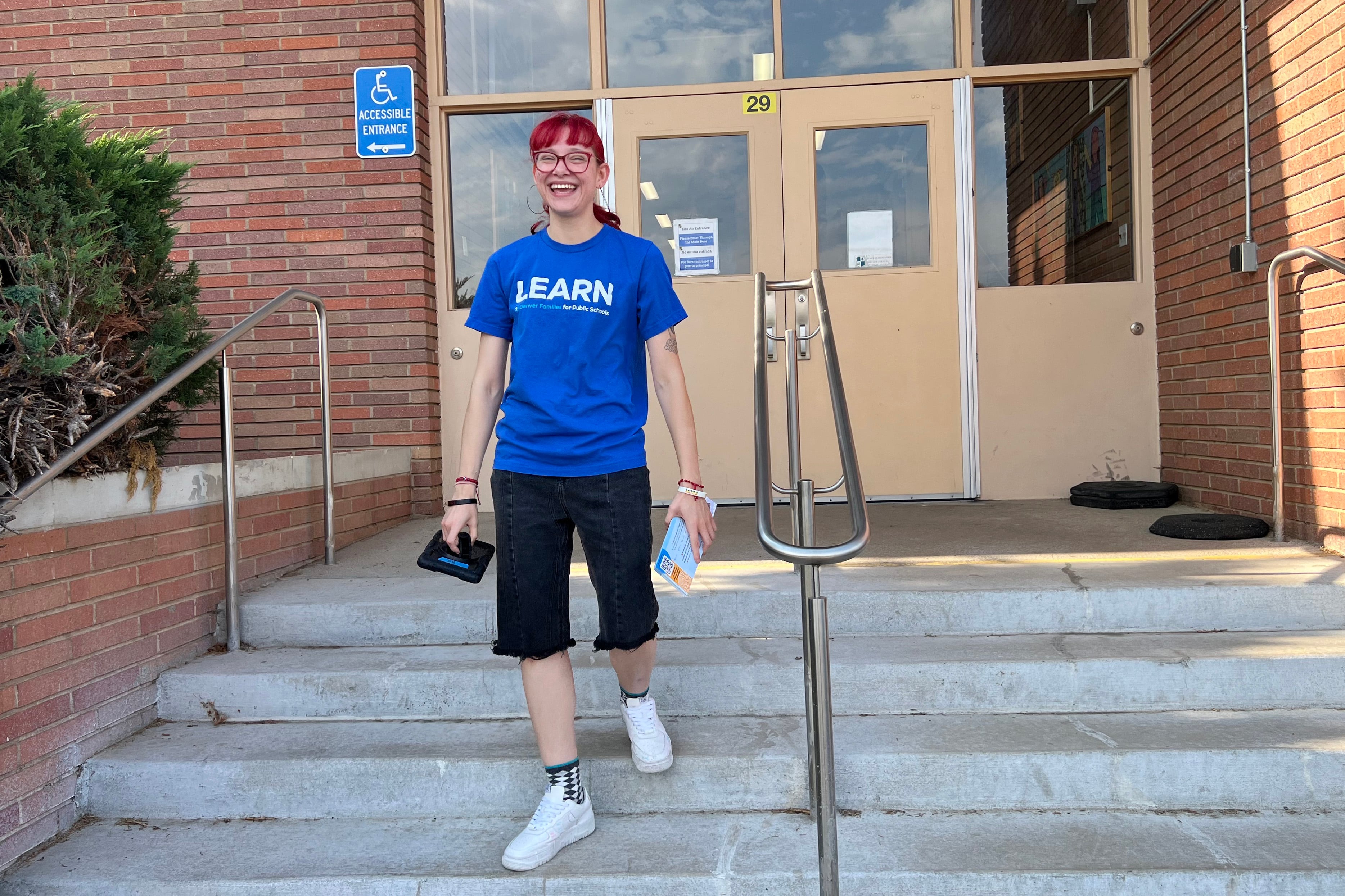 A woman in a blue t-shirt walks down stairs.