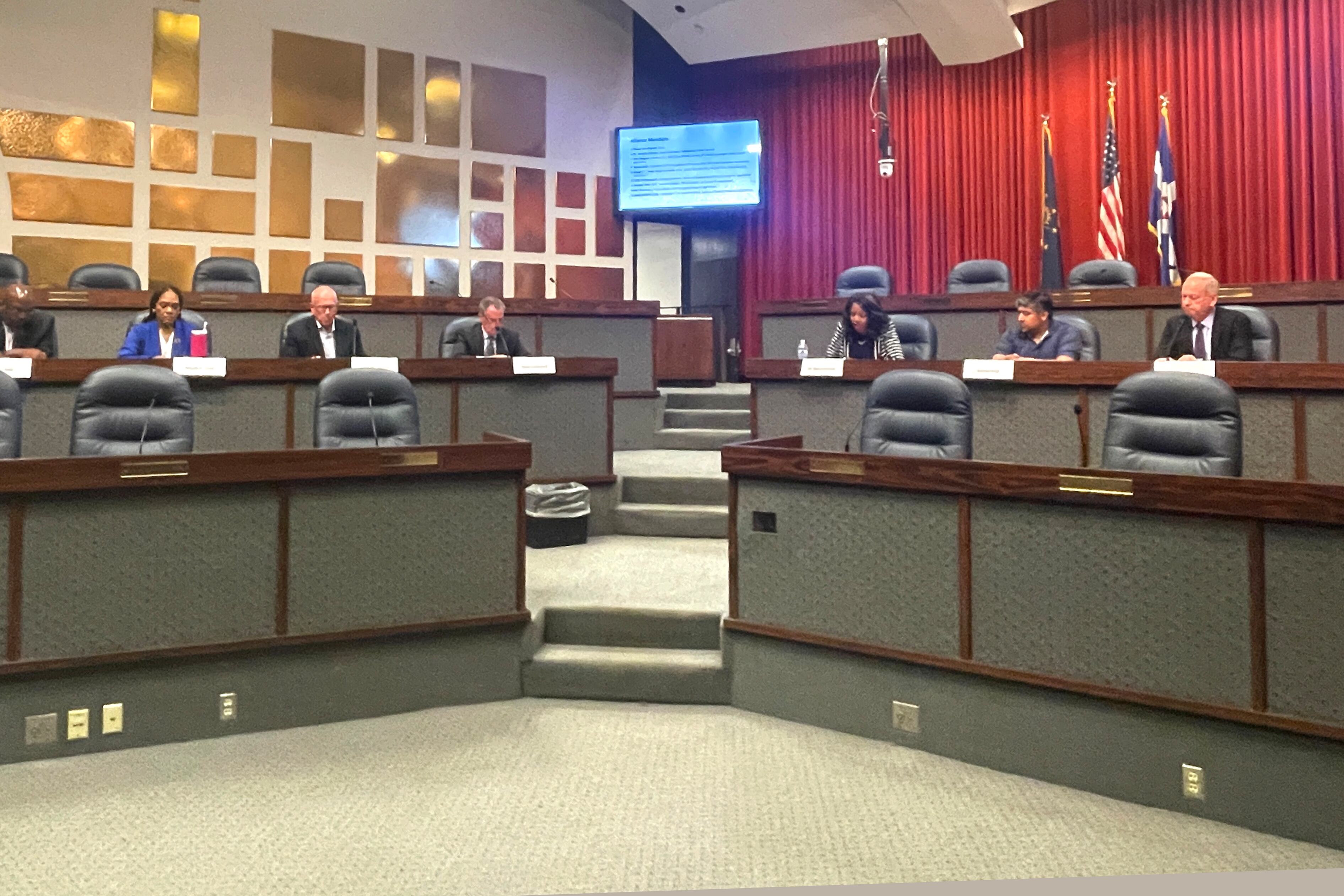 People sit at the front of an official room.