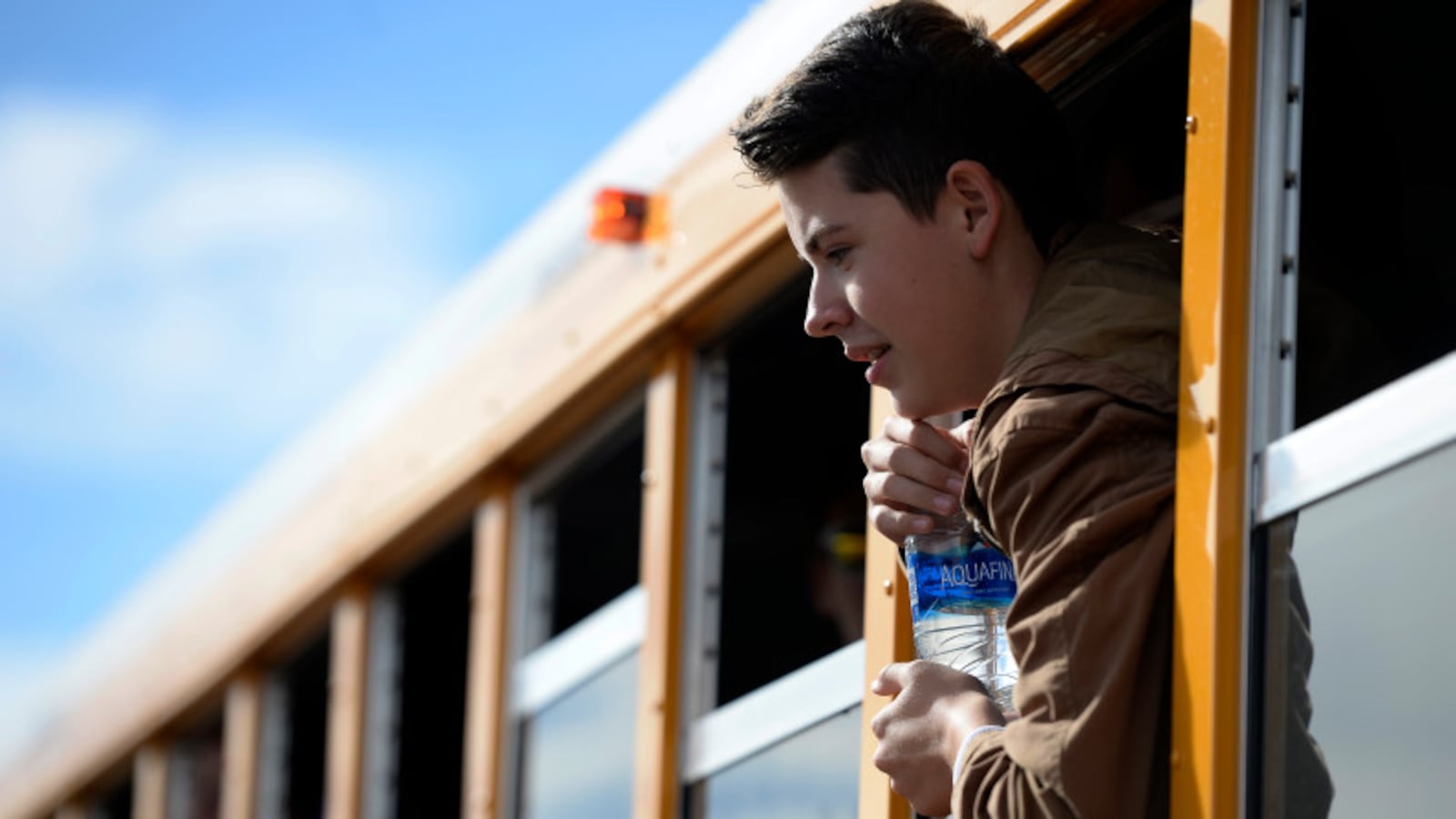 Haylen Orgunez, 14, hangs out the window of one of the new compressed natural gas buses as he poses for a group photo at Douglas County High School in Castle Rock, Colorado on November 16, 2016.  (Photo by Seth McConnell/The Denver Post)