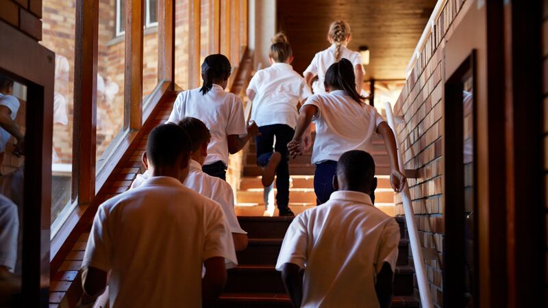 students in uniforms going up steps
