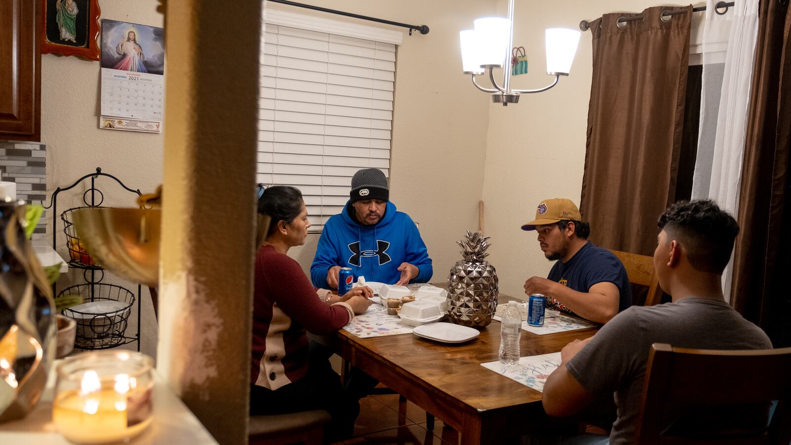 A family of four enjoy dinner together at their dining room table.