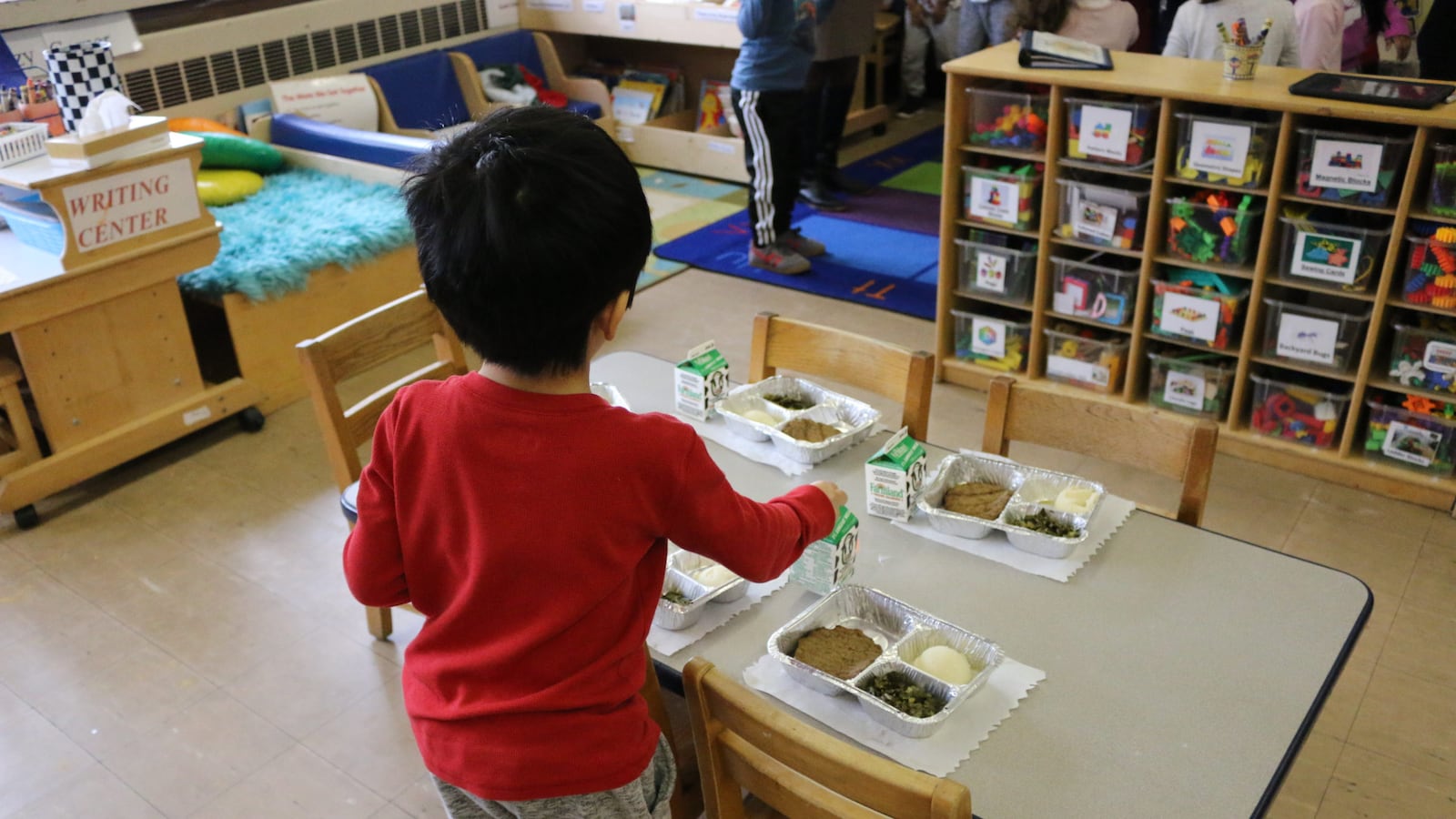 A pre-K student at HeartShare Taranto in Brooklyn helps prepare the classroom for lunch.