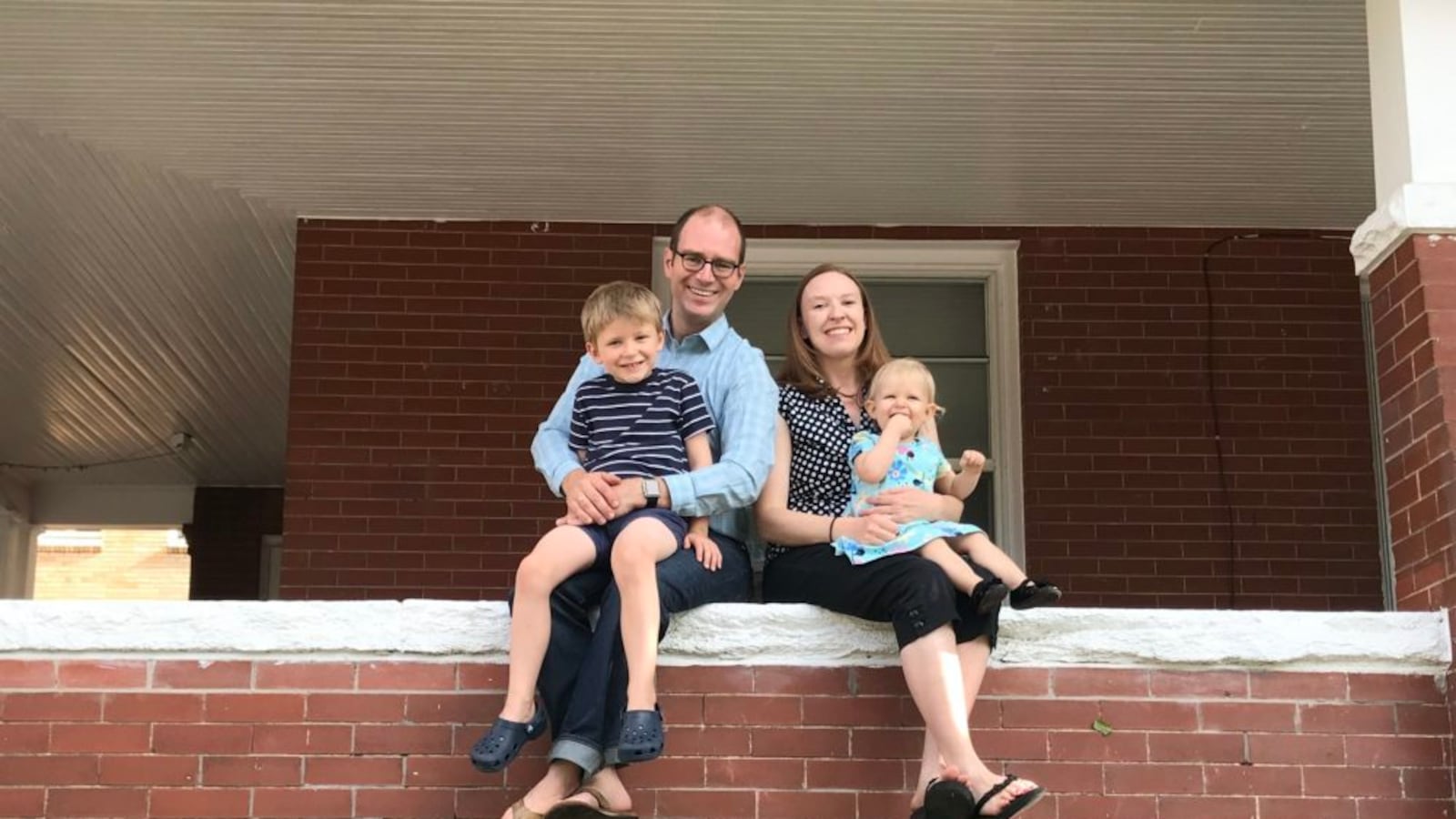 Brad Laurvick on his porch with his wife and two children.