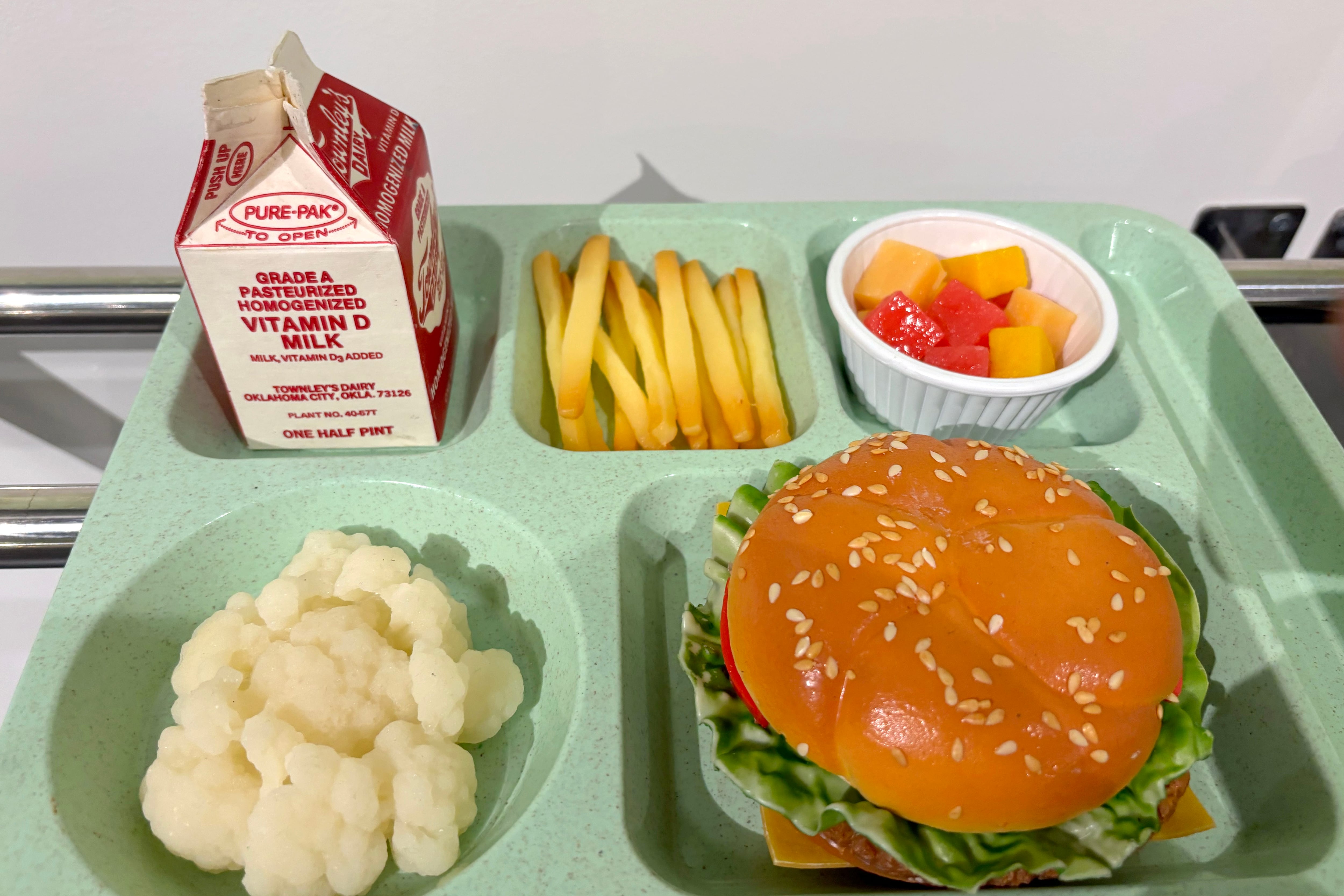 A fake school lunch on a green tray.