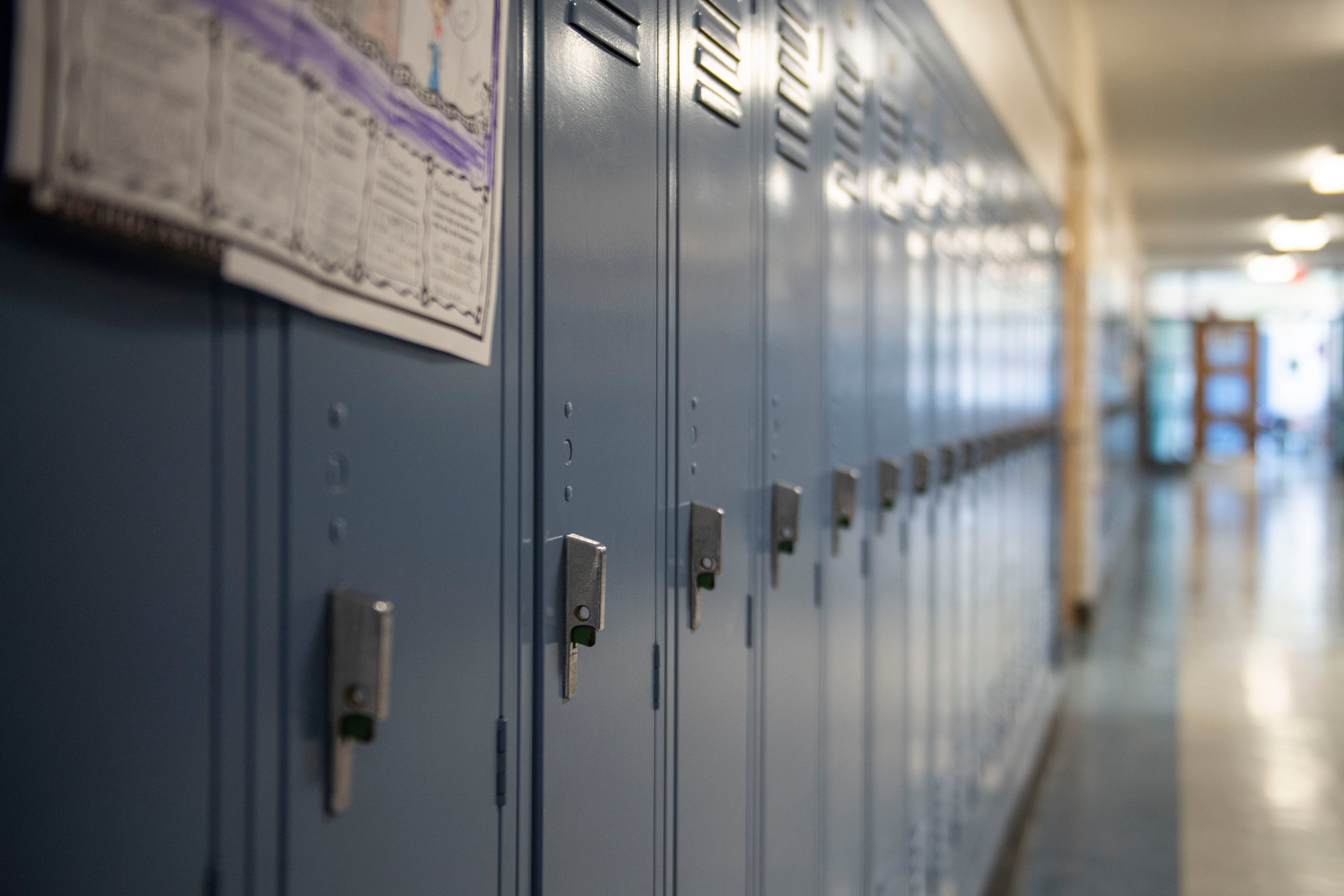 A row of blue lockers in a school hallway