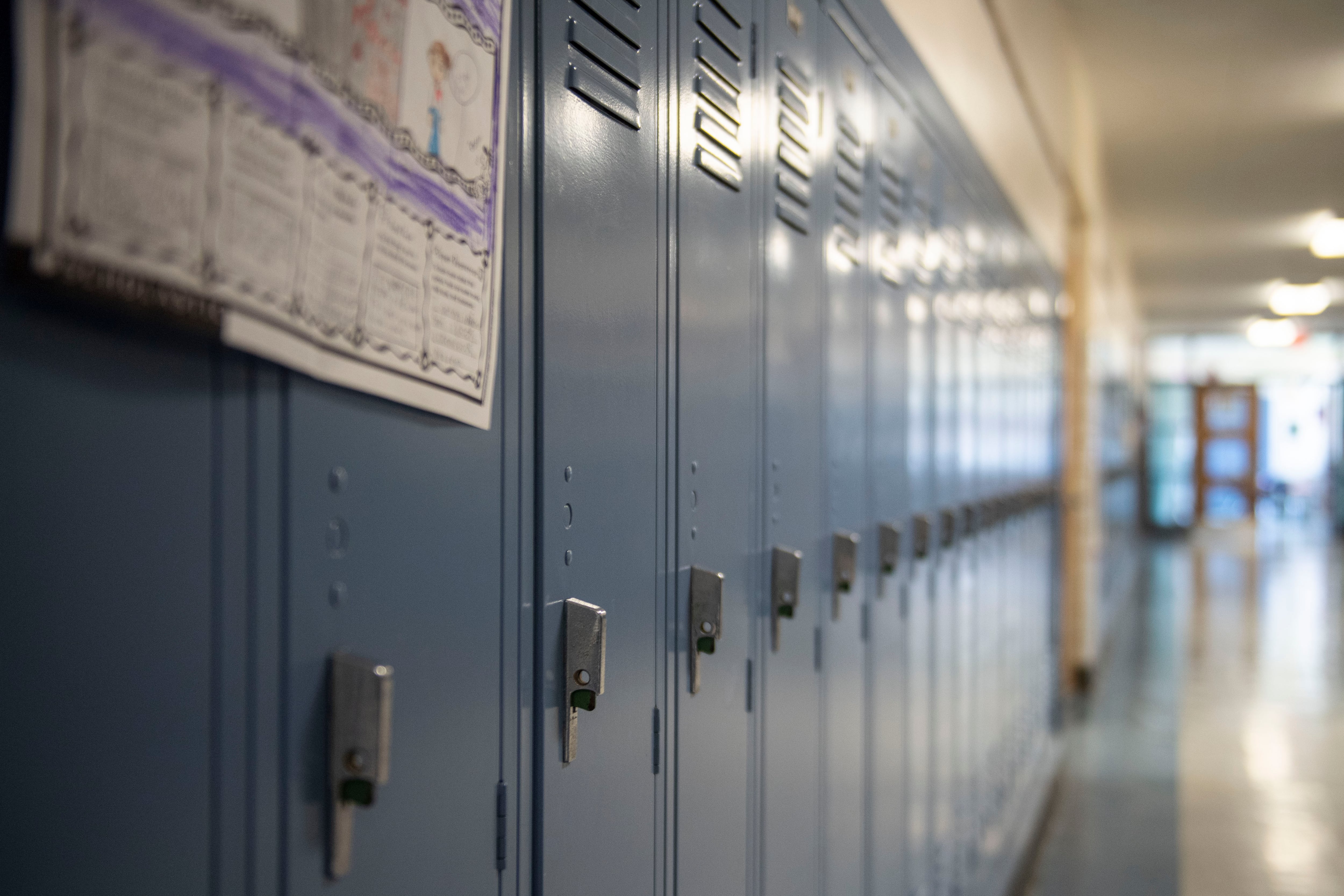 A row of blue lockers in a school hallway