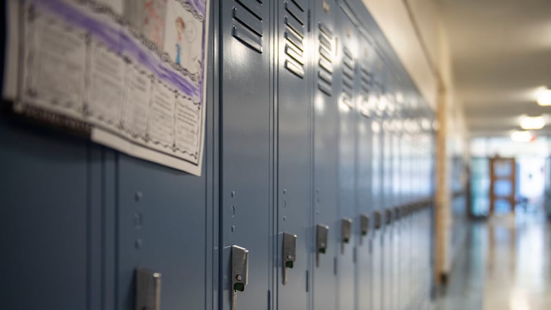 A row of blue lockers in a school hallway