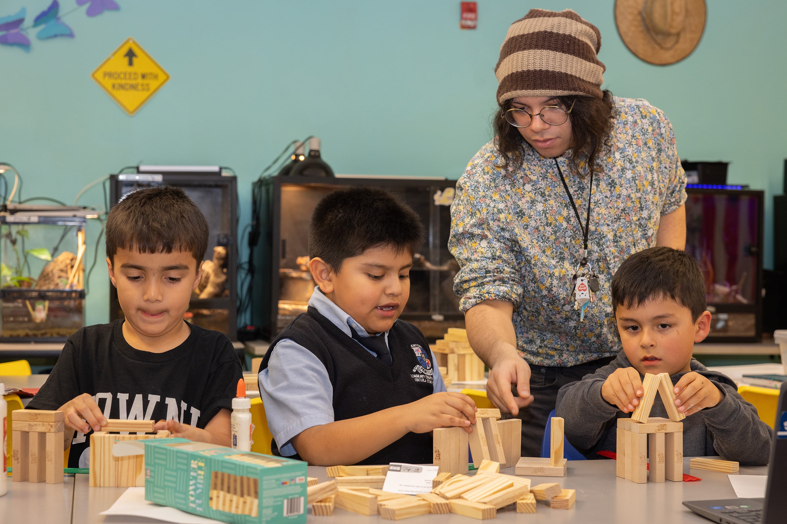 A photograph of a teacher working with three young students.