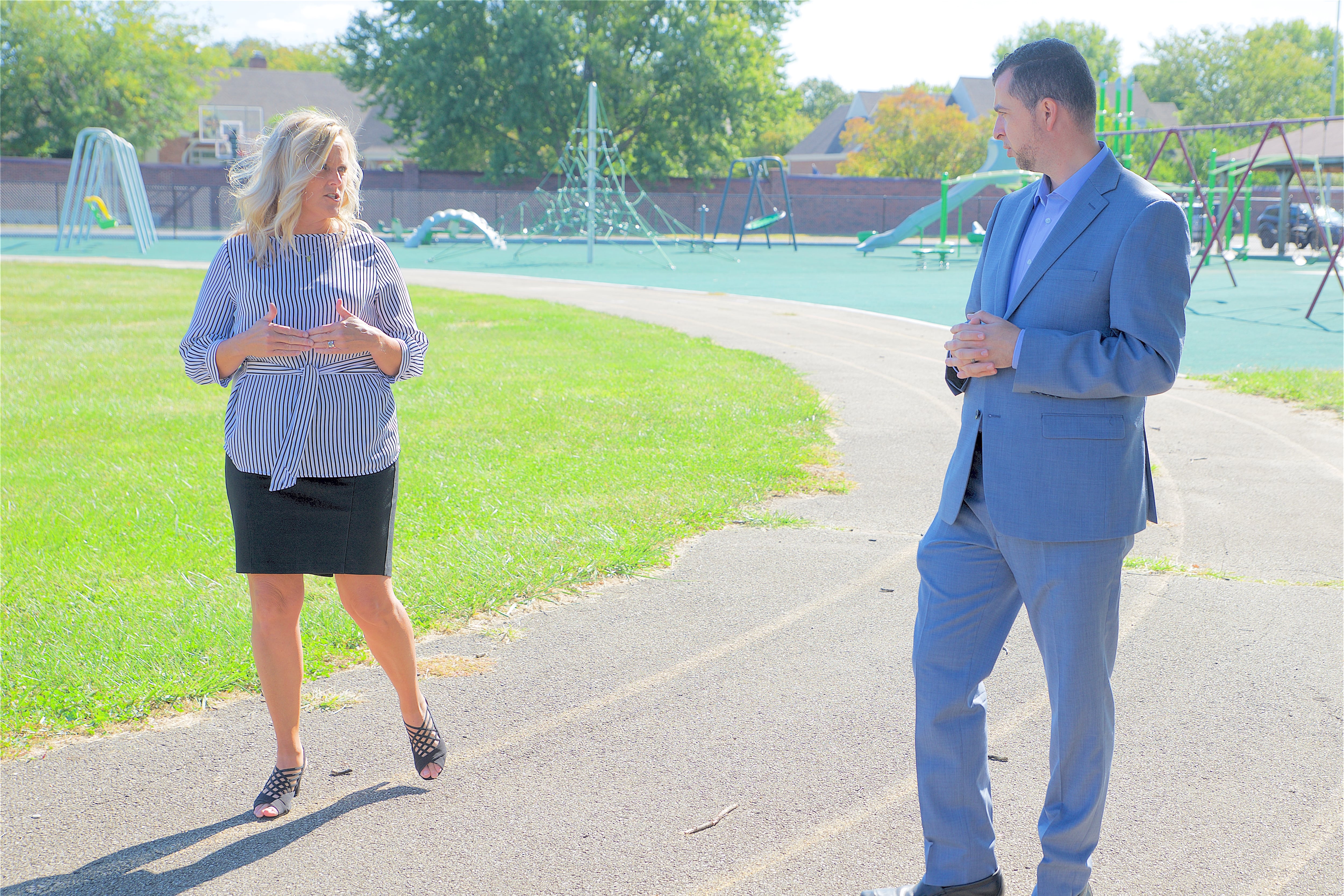 Indiana education chief Jennifer McCormick and Democratic state Senate candidate Fady Qaddoura.walk on a track as part of a political ad.