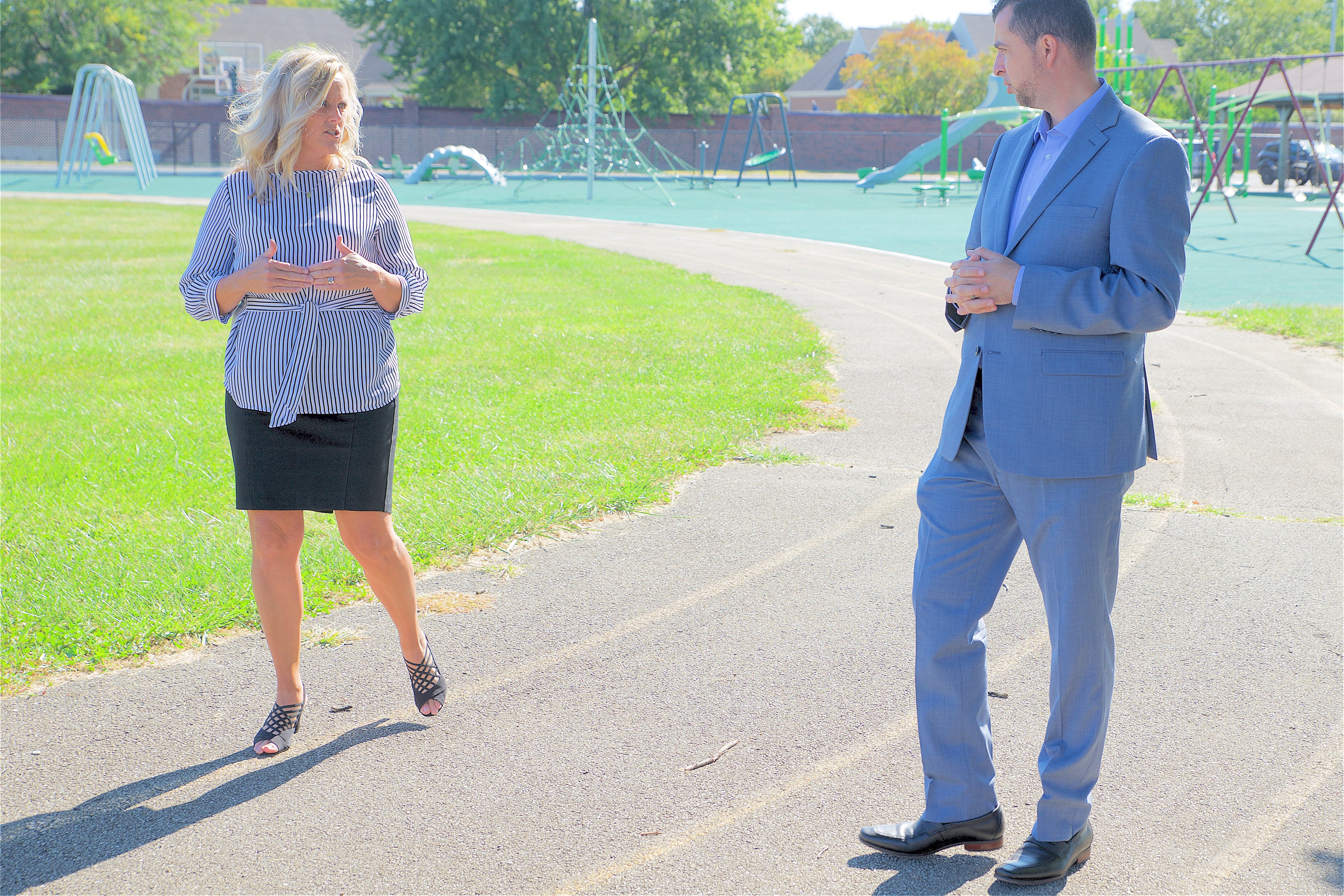 Indiana education chief Jennifer McCormick and Democratic state Senate candidate Fady Qaddoura.walk on a track as part of a political ad.