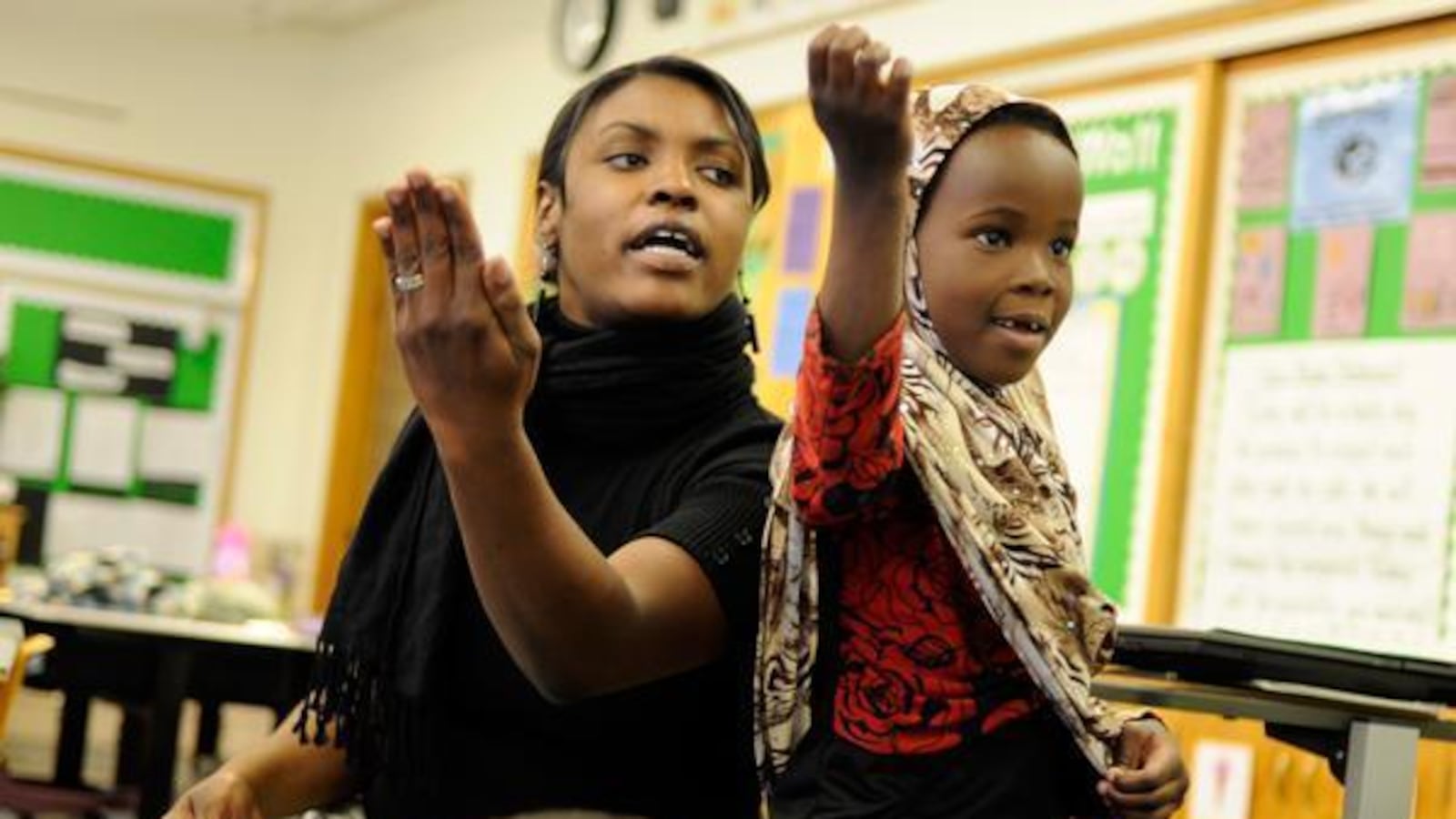 McMeen Elementary teacher JaMese Stepanek reads poetry with first-grader Citi Hejab.