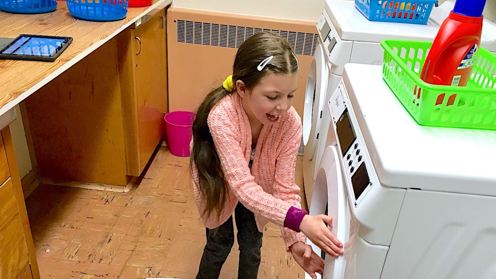 Morgan Pohl, a third-grader at Doull Elementary in Denver, prepares to do a load of laundry at school.