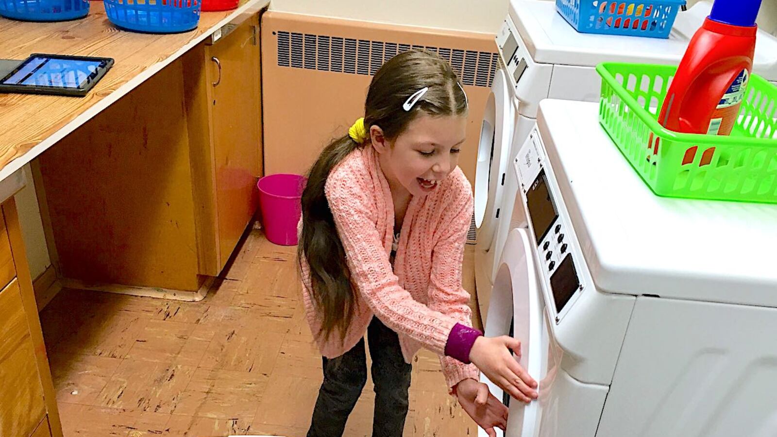 Morgan Pohl, a third-grader at Doull Elementary in Denver, prepares to do a load of laundry at school.