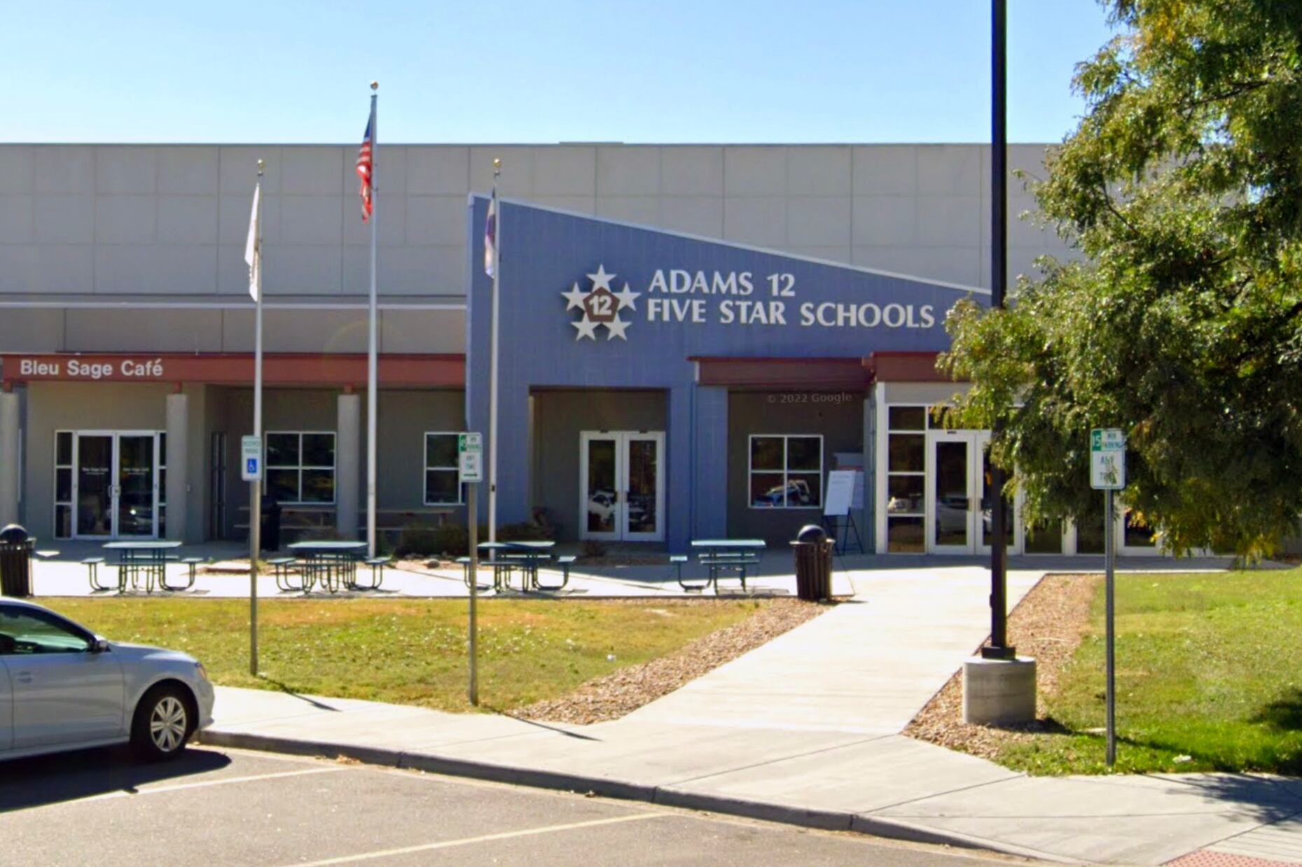 Photo shows Adams 12 Five Star Schools district offices in Thornton. The blue entryway has a sharp angle with a large sign with the district name.