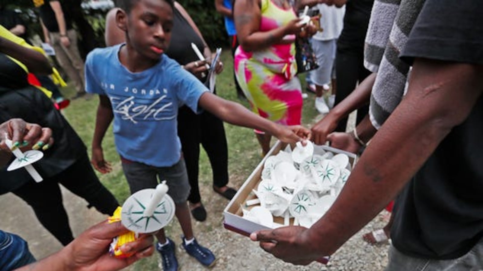 Candles are passed out as community members gather near the Frayser home of Brandon Webber on Friday, June 14, 2019.