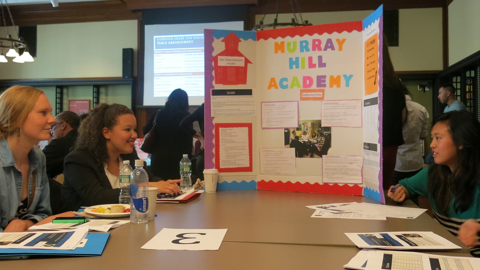 Cristal Cruz, second from left, and Salina Kuoc, right, discuss a mentoring project.