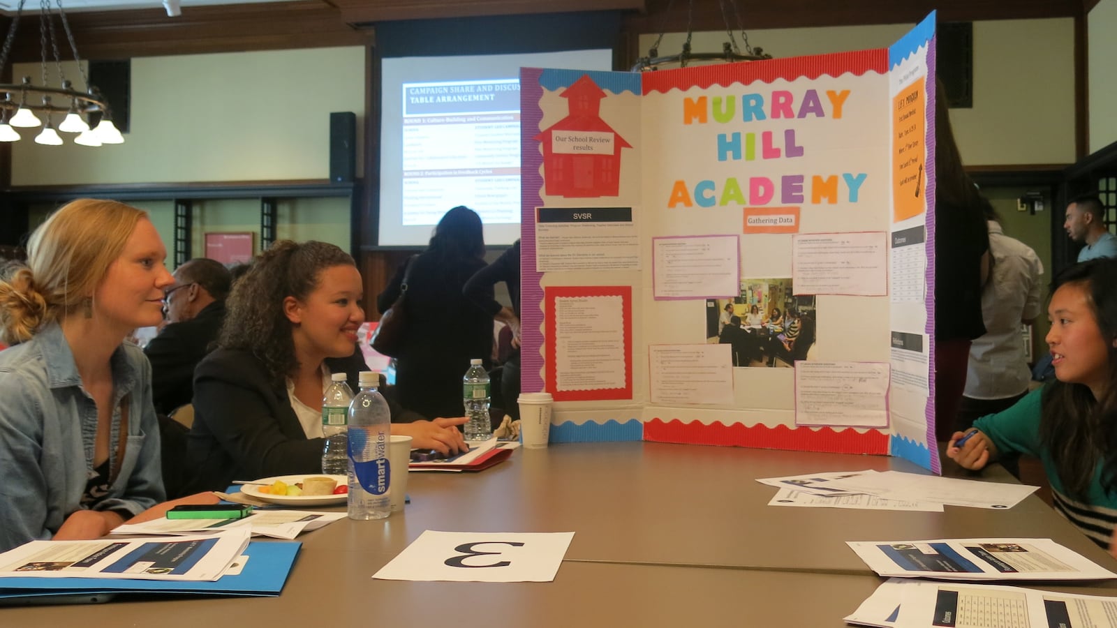 Cristal Cruz, second from left, and Salina Kuoc, right, discuss a mentoring project.
