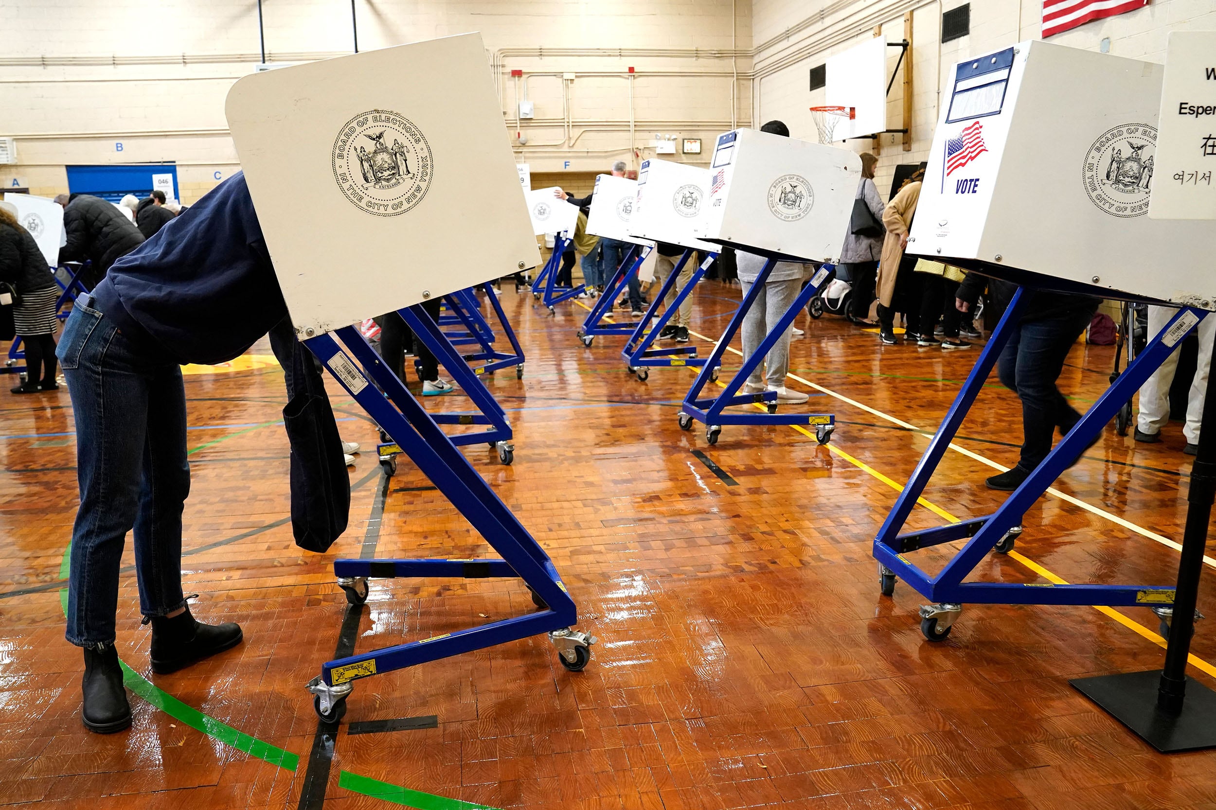 Rows of mobile polling booths in a school gym.