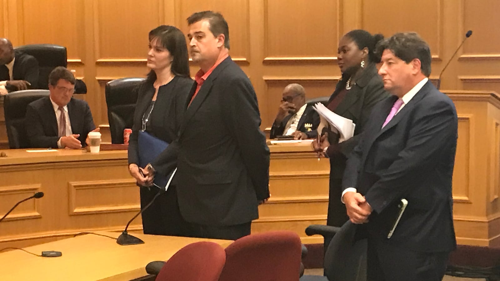 McQueen (far left) pauses with her team, including Questar CEO Stephen Lazer (far right), to hear a few final comments from lawmakers.