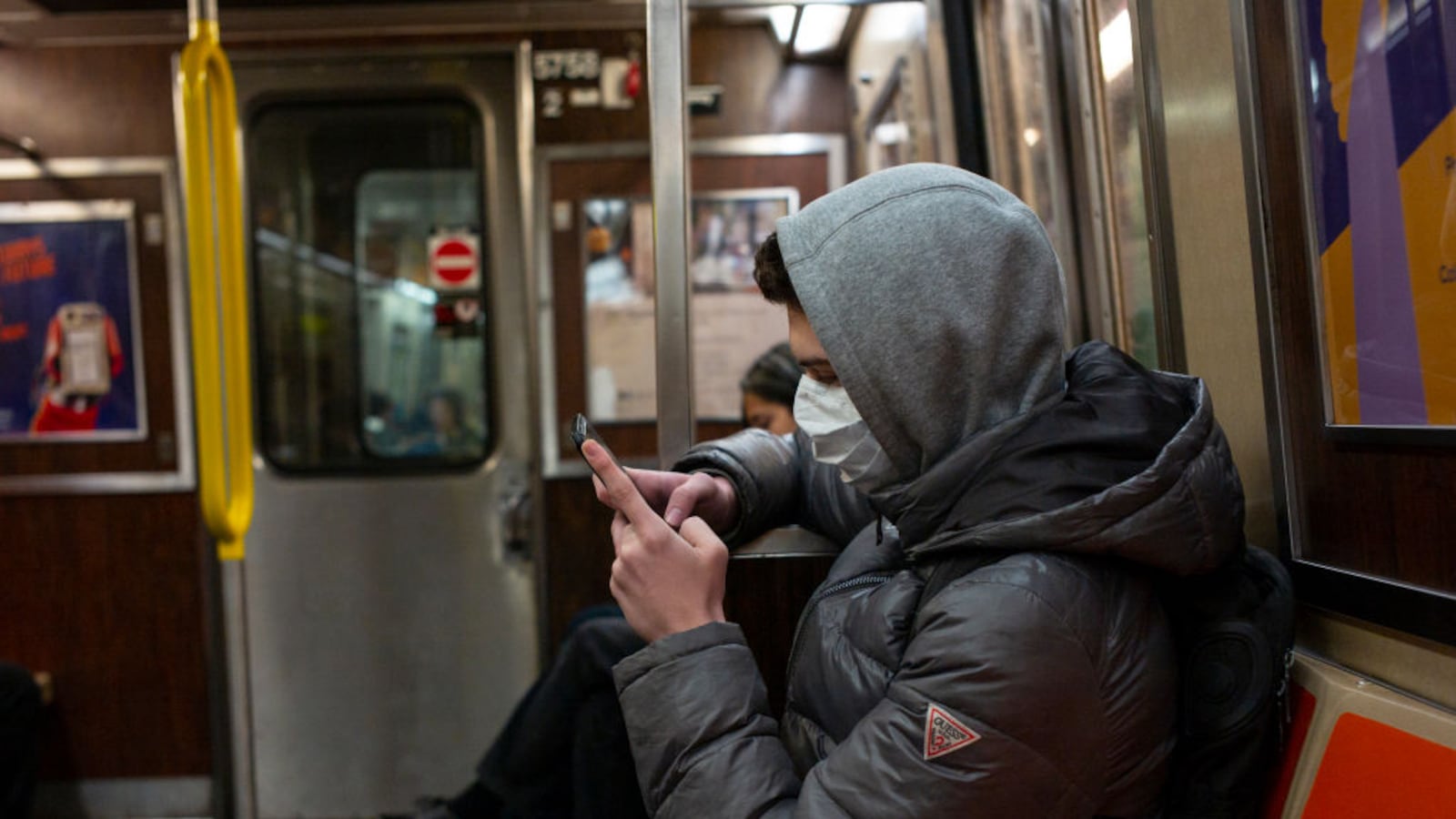 A man riding the subway in Brooklyn wears a medical facemask out of concern over the coronavirus.