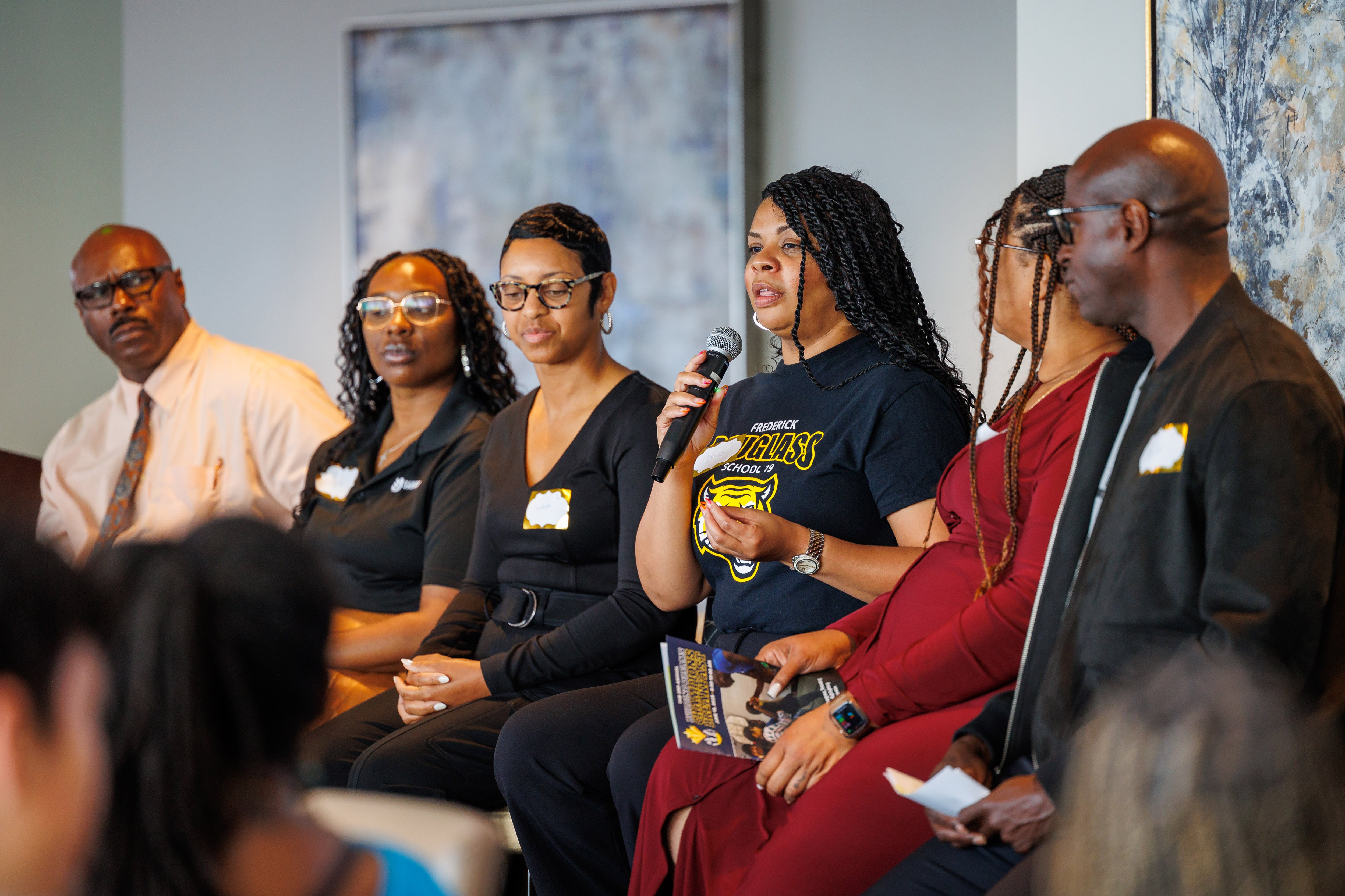 A woman in a navy shirt speaks surrounded by others