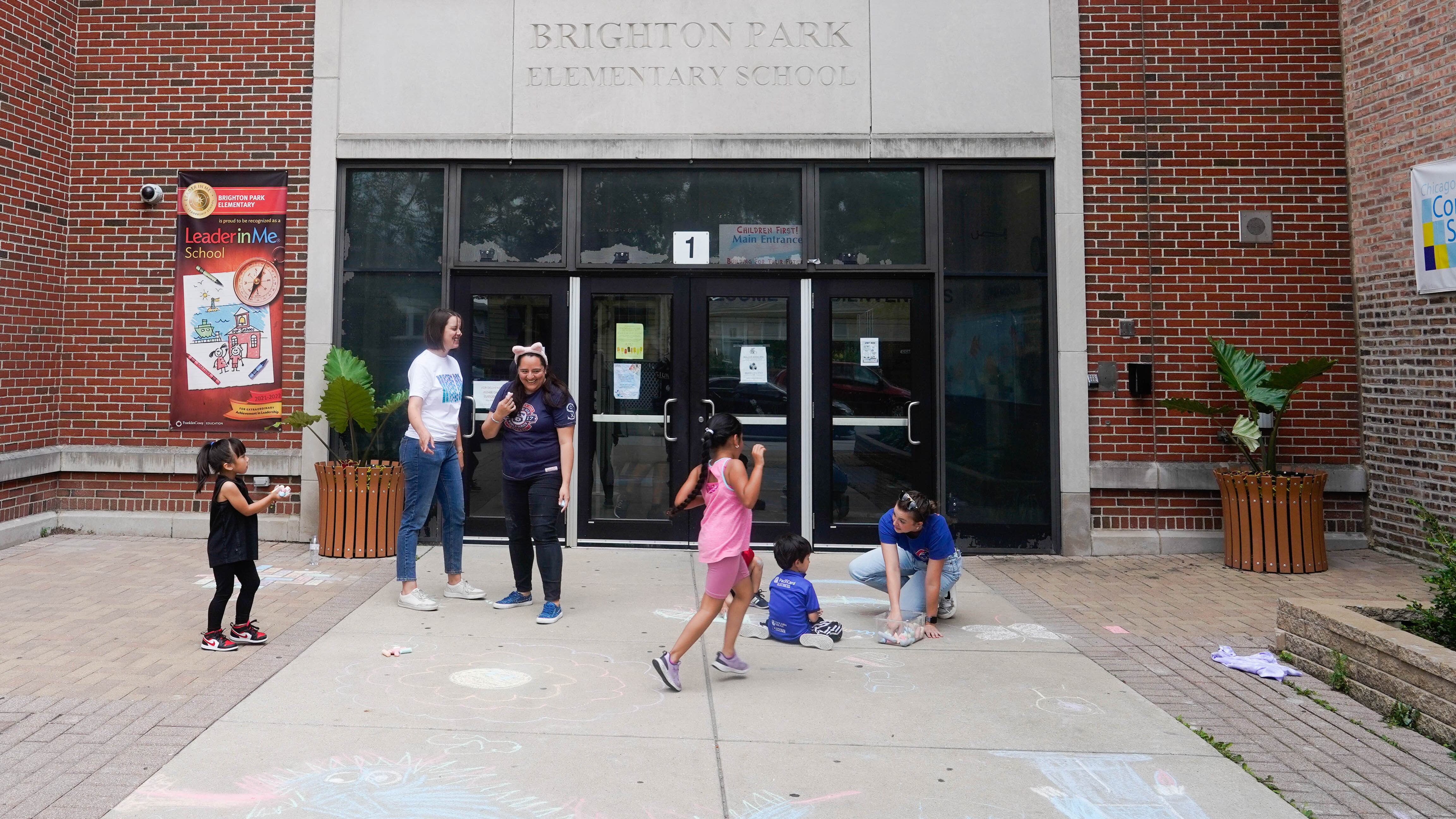 Students and teacher play in front of Brighton Park Elementary School on the city’s south west side.