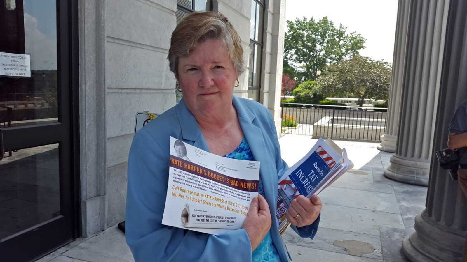 Representative Kate Harper holding a flyer.