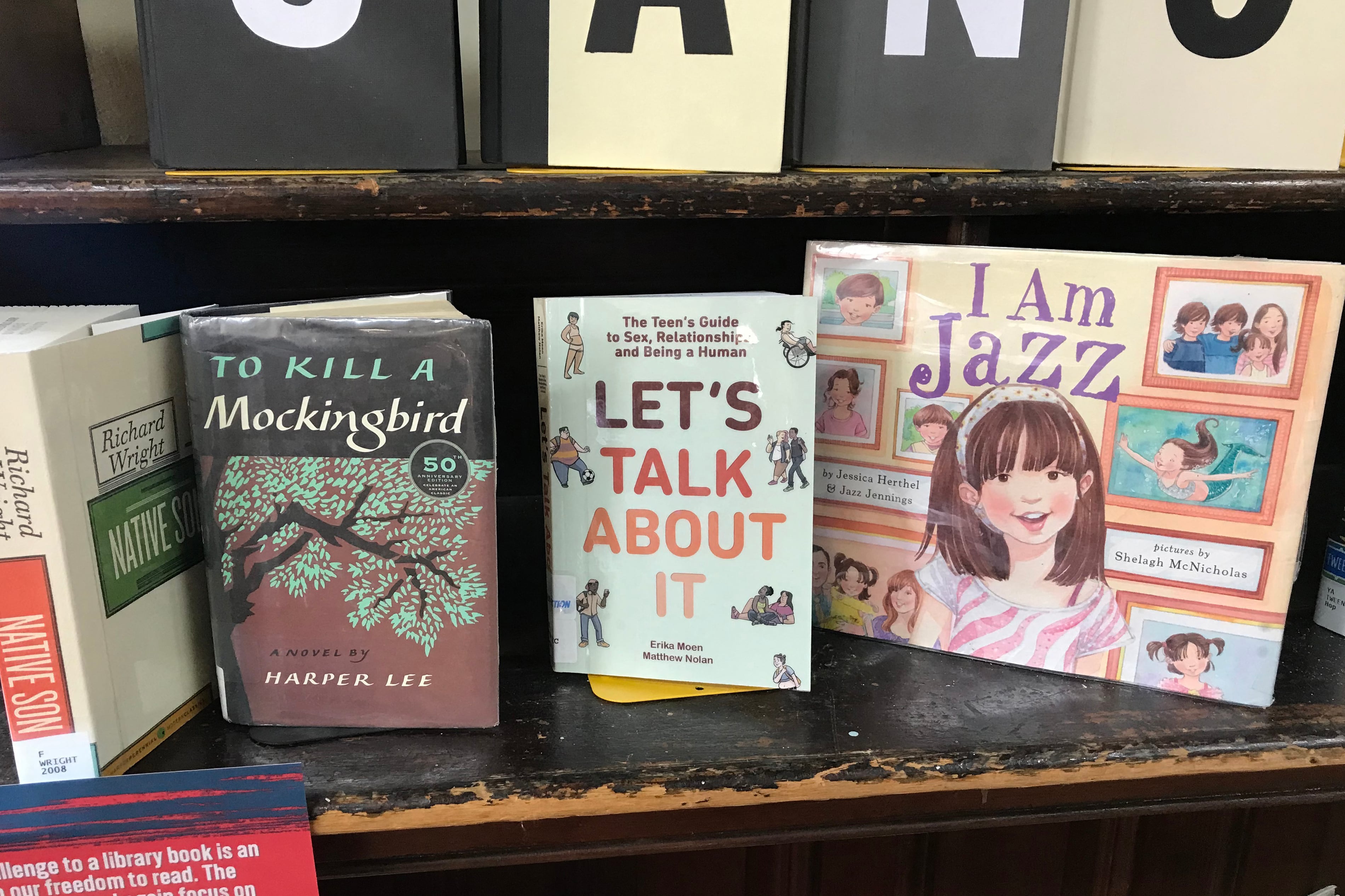 Four books stand up on a bookshelf.