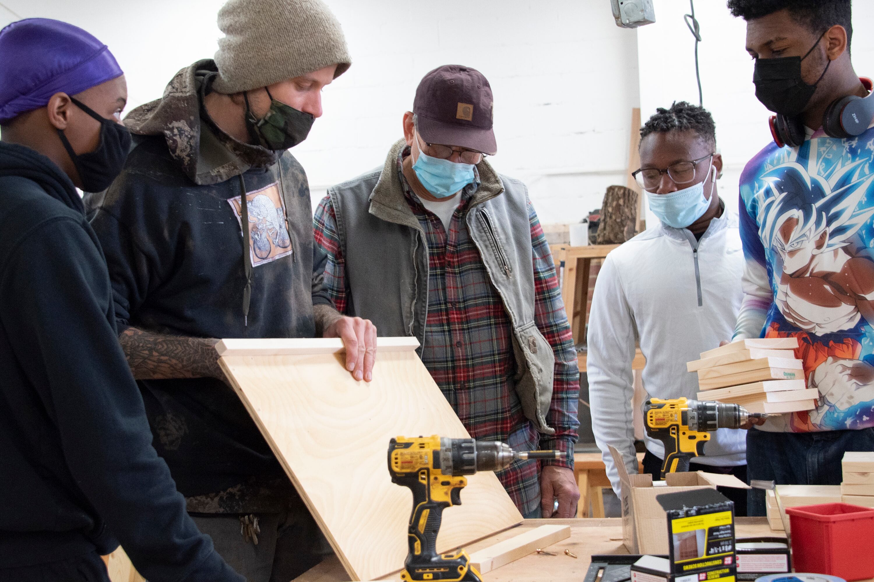 Students and adults work on building desks for remote learners