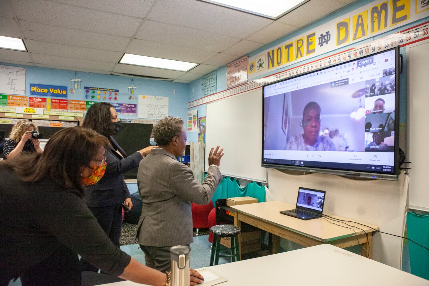 Mayor Lori Lightfoot talking to students over video chat on a large screen.