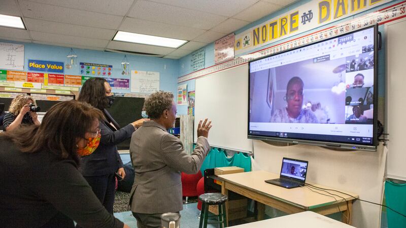 Mayor Lori Lightfoot talking to students over video chat on a large screen.