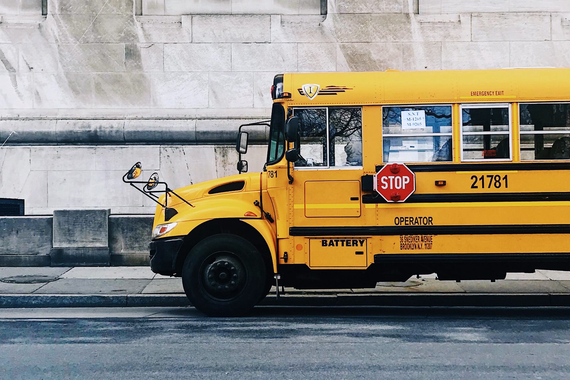 Yellow school bus driving along a city street.