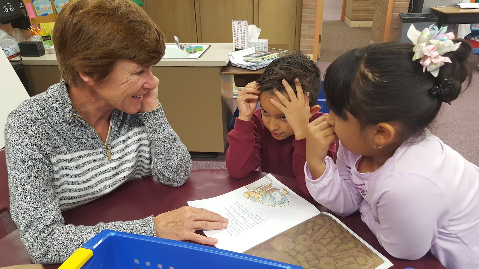 Volunteer Cindy Stechmeyer reads with two second graders during reading club at Lumberg Elementary in Edgewater.