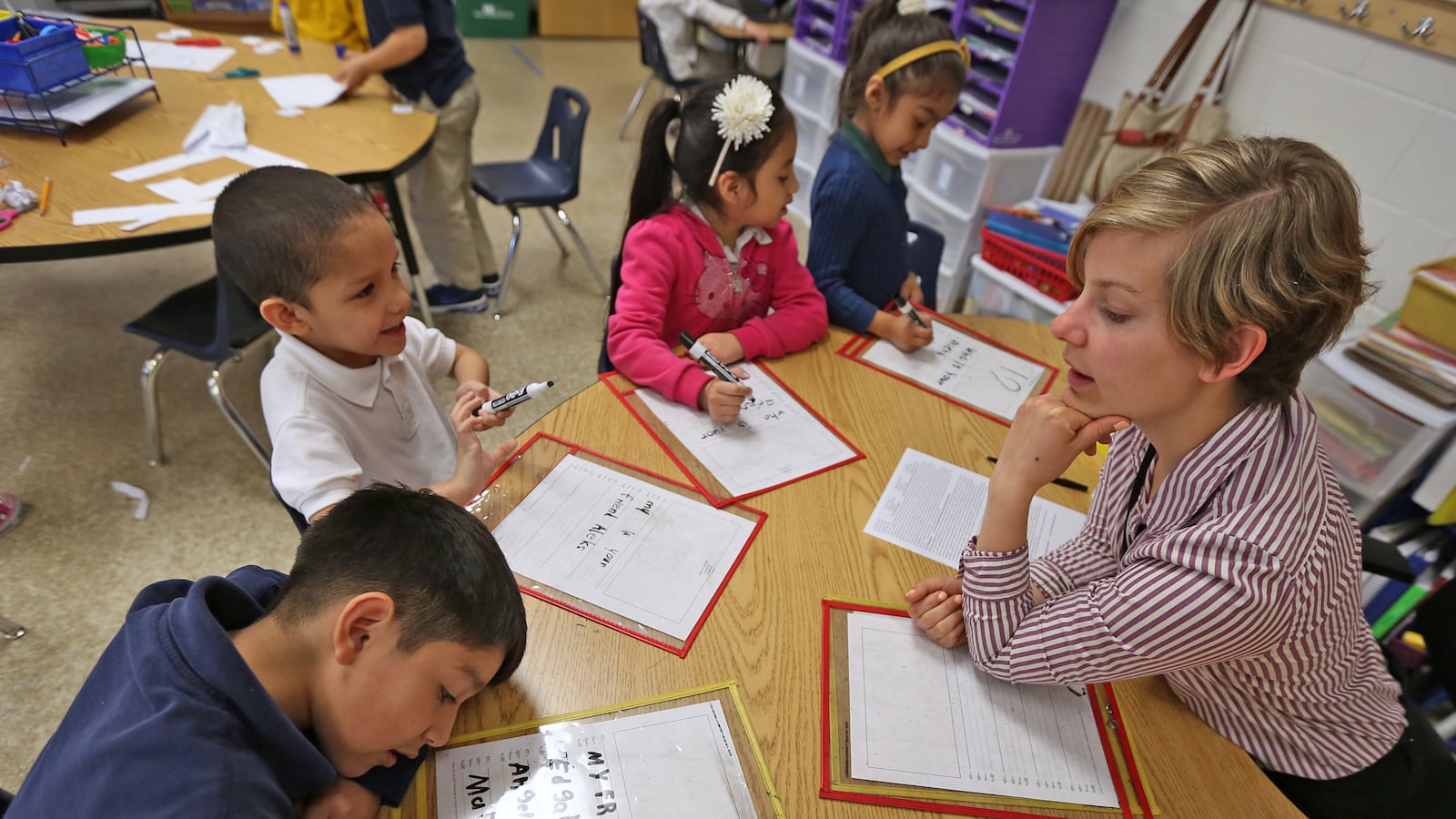 Lead Kindergarten teacher Liz Amadio, right, works with students at Enlace Academy.