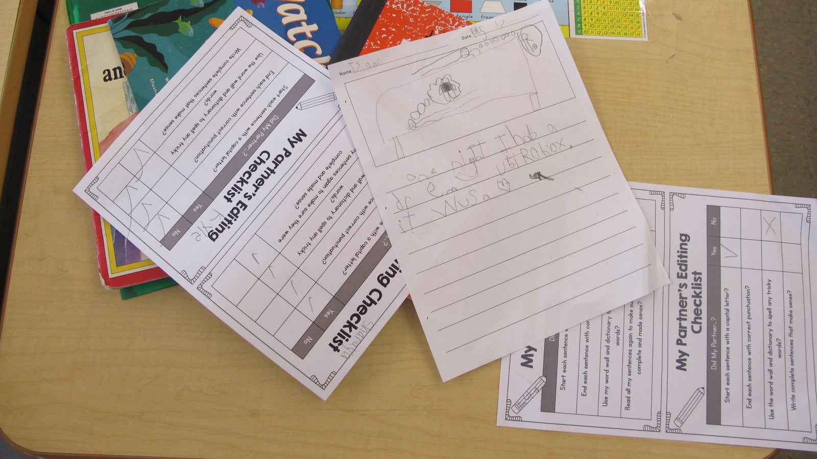 A student's writing work is scattered across a desk in a Brooklyn elementary school.