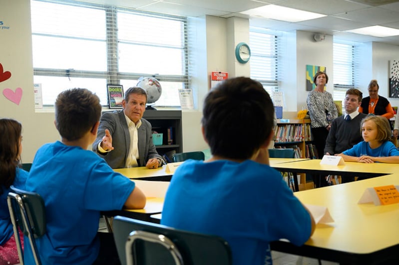 Tennessee Governor Bill Lee speaks with students wearing blue shirts.