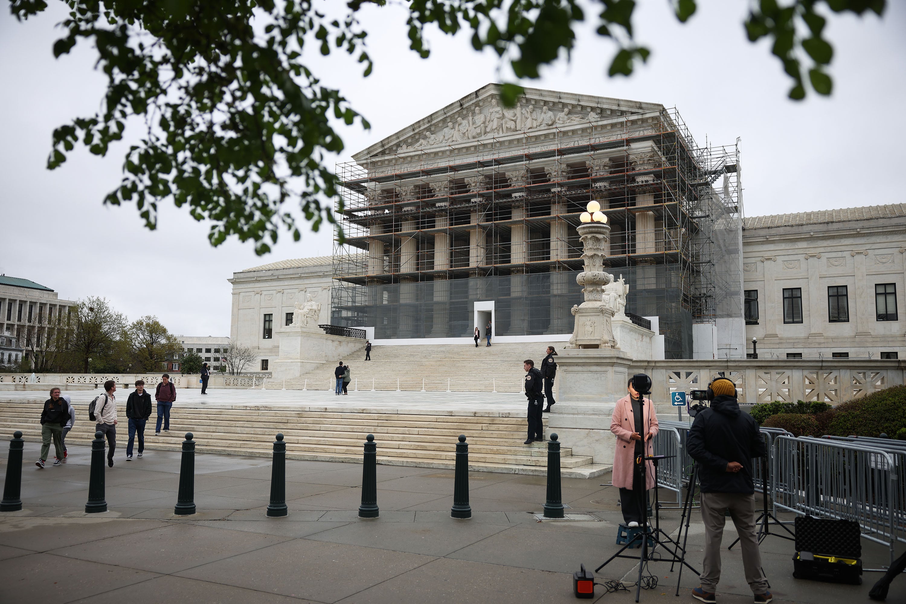 A small group of people stand around the U.S. Supreme Court building while it's under construction.