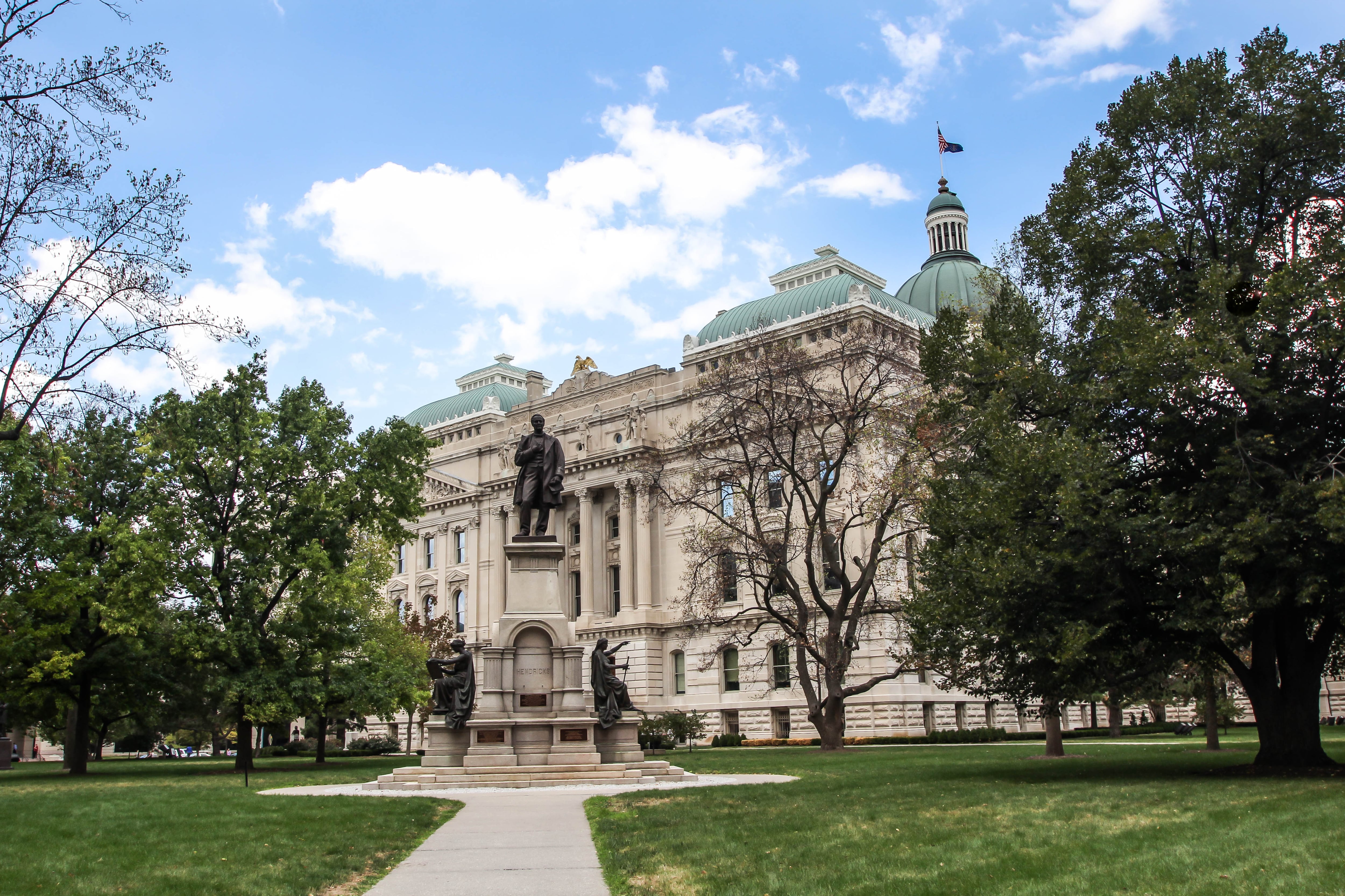 A building with trees and a statute out front.