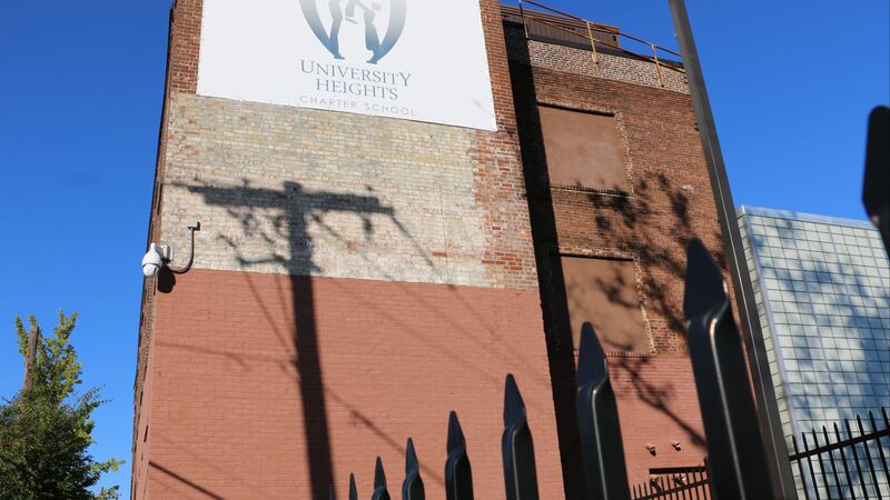 Light posts cast shadows on the brick facade of University Heights Charter School in Newark.