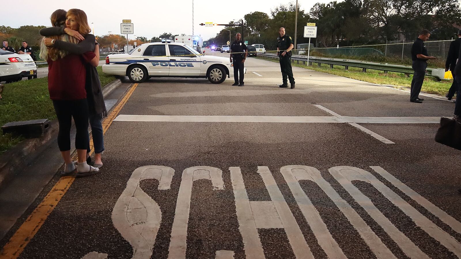 Kristi Gilroy (right) hugs a young woman at a police check point near the Marjory Stoneman Douglas High School where 17 people were killed by a gunman in Parkland, Florida. (Photo by Mark Wilson/Getty Images)