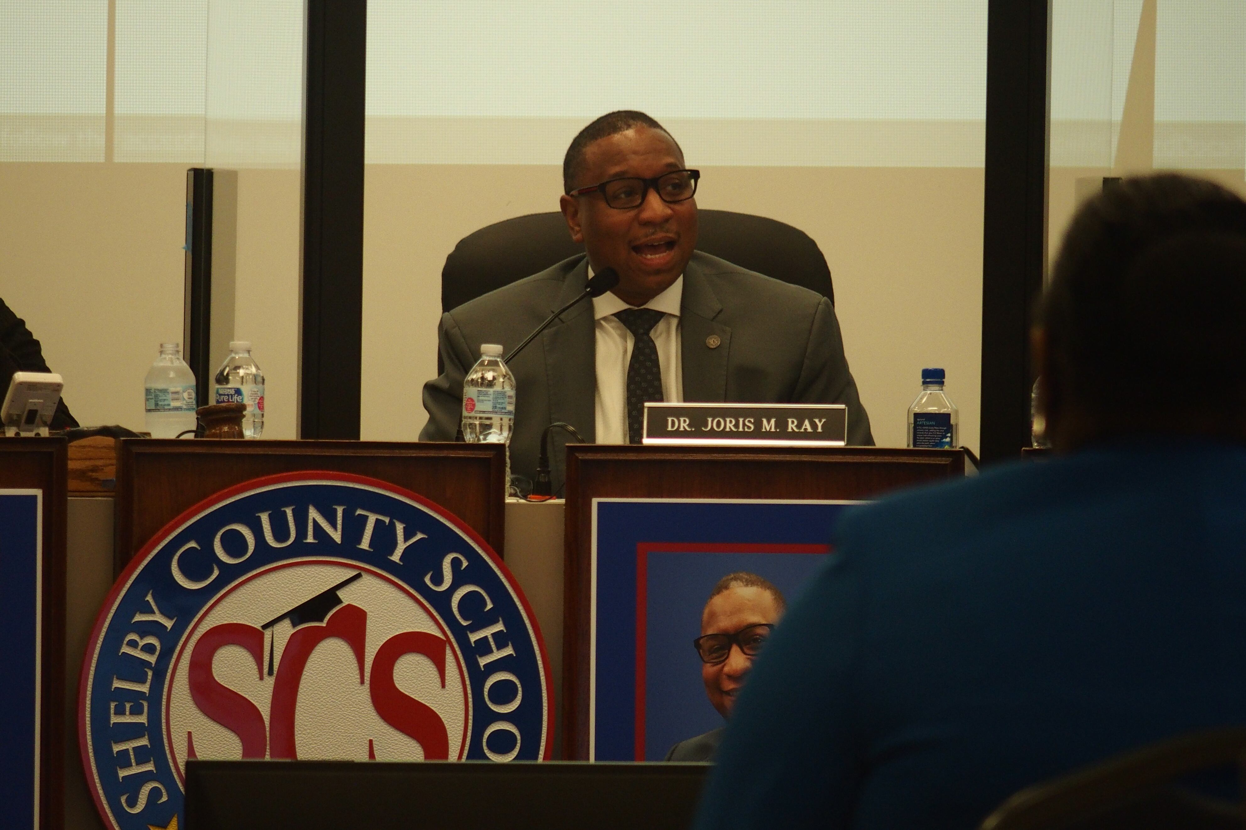 Superintendent Joris Ray sits with school board members separated by plastic dividers during a meeting at the district’s headquarters