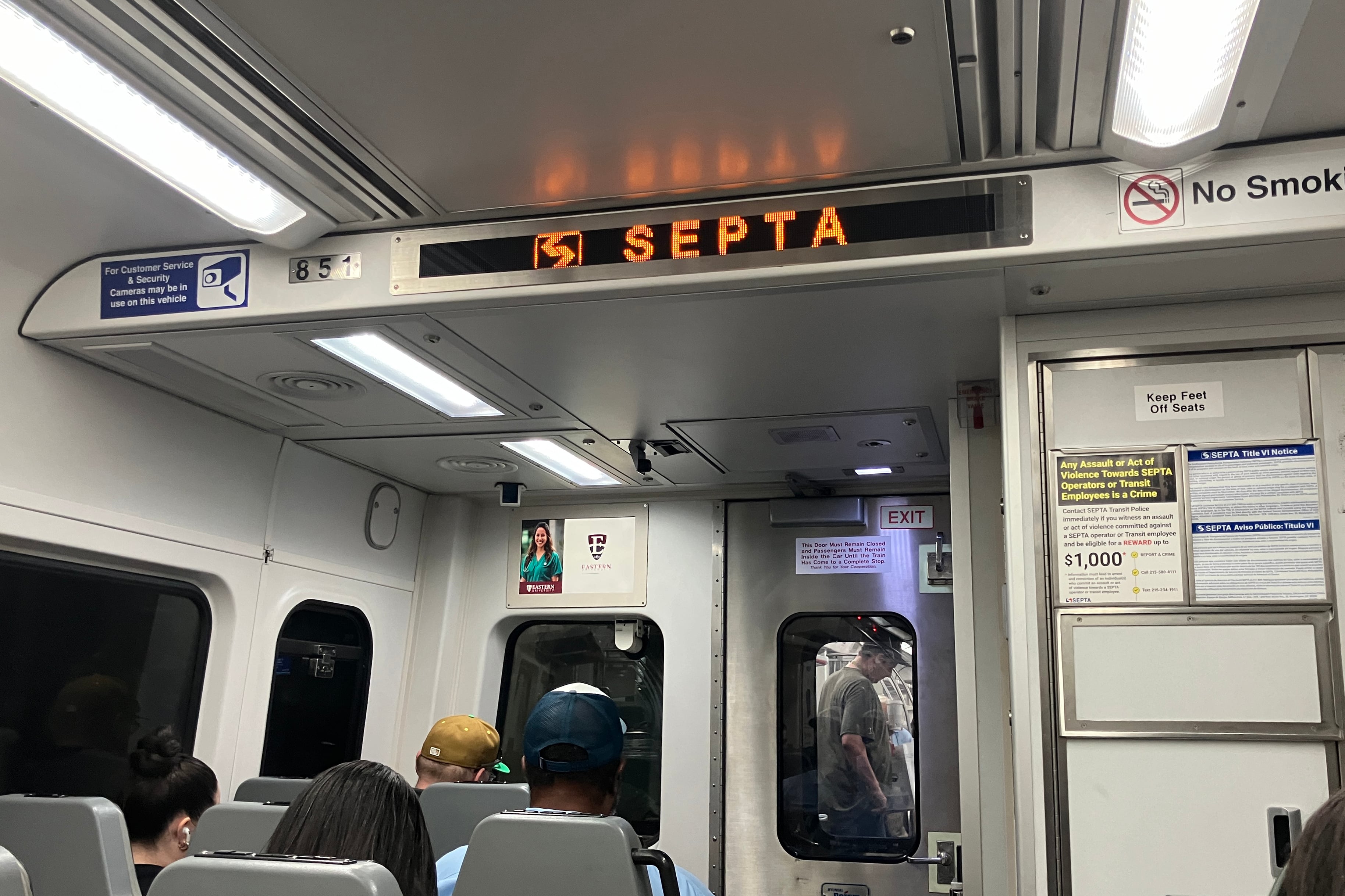 A photograph of the inside of a SEPTA train car with two rows of people sitting.