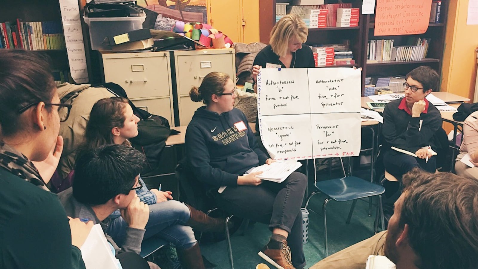The author, sitting to the left of sign, at a Teachers Unite workshop for educators on restorative justice in 2015.