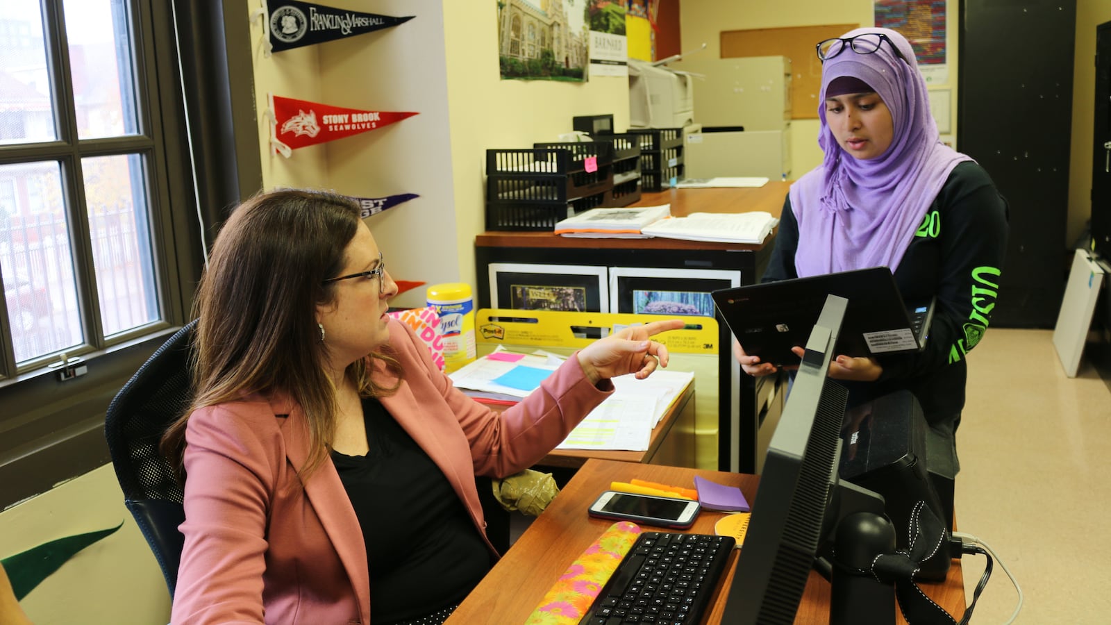 College counselor Jessica Kane, left, helps a student with her college application. Through a program called College Bound Initiative, Kane helps students at The Young Women's Leadership School of Queens learn the intricacies of applying to college.