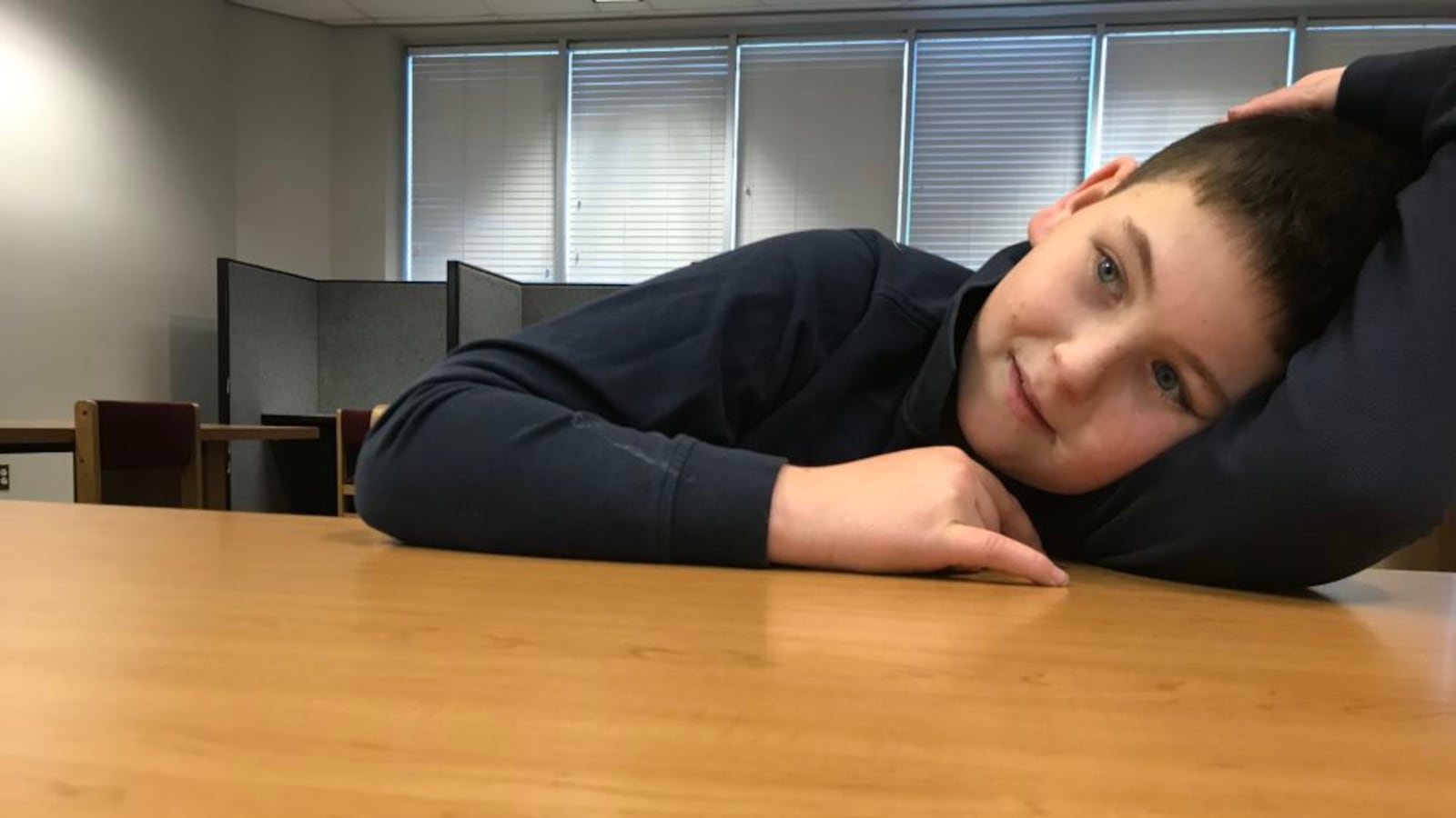 Jake DiProfio rests his head on a table at the local library during a tutoring session.